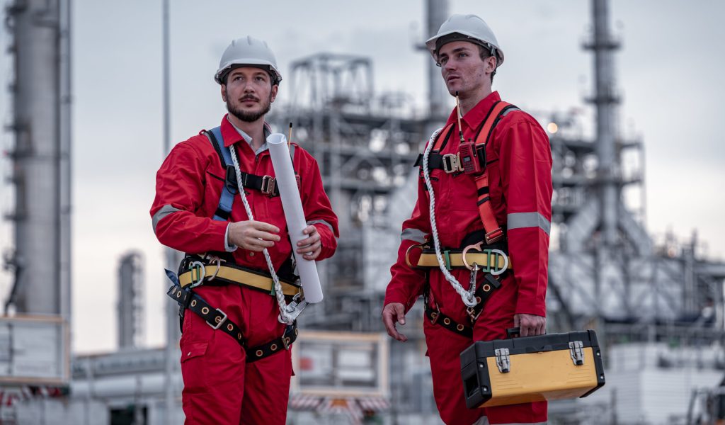 Engineer survey team wear uniform and helmet stand workplace checking blueprint project radio communication