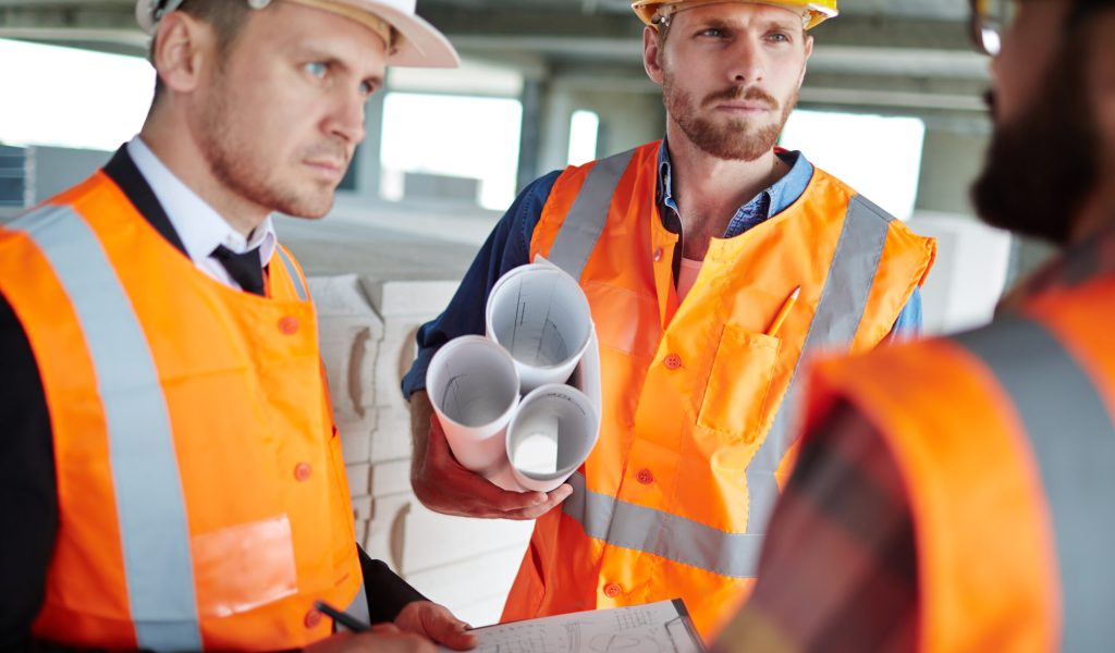 Young architects in uniform discussing what to do next
